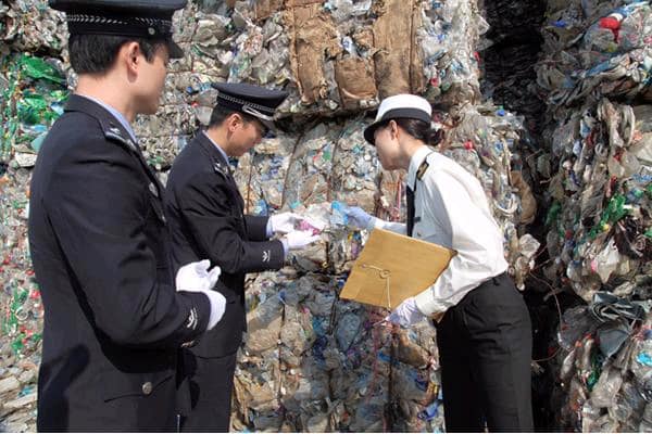 Chinese customs officials inspect a shipment of waste PET plastic bottles